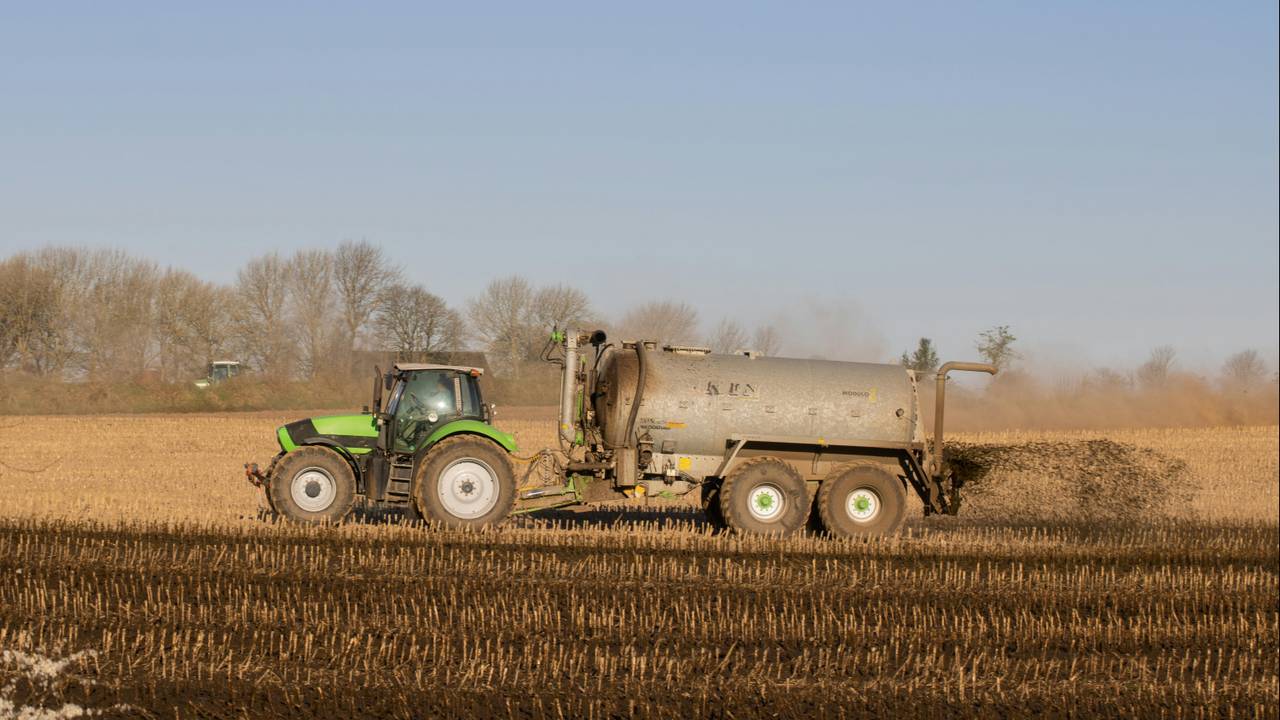 Een boer rijdt mest uit (archieffoto: Mirko Fabian / Pexels).