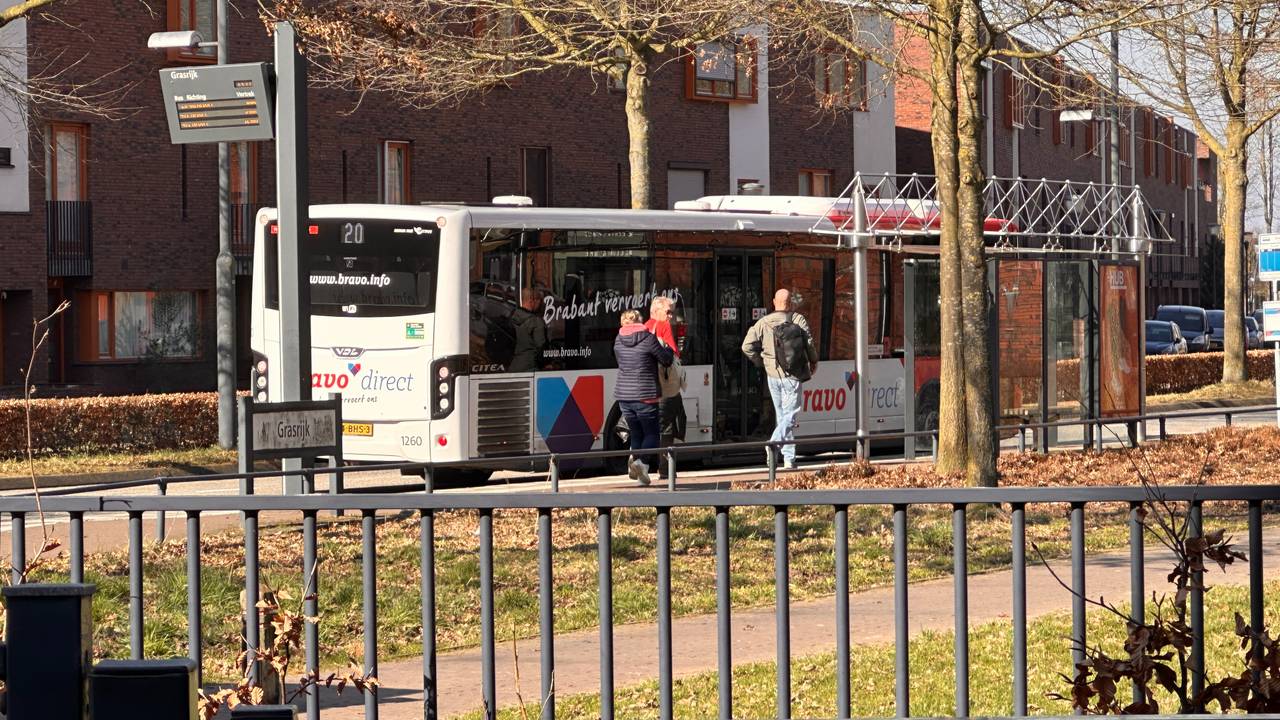 Vakantiegangers die hun auto in de wijk geparkeerd hebben stappen in de bus naar het vliegveld (foto Jan Peels)