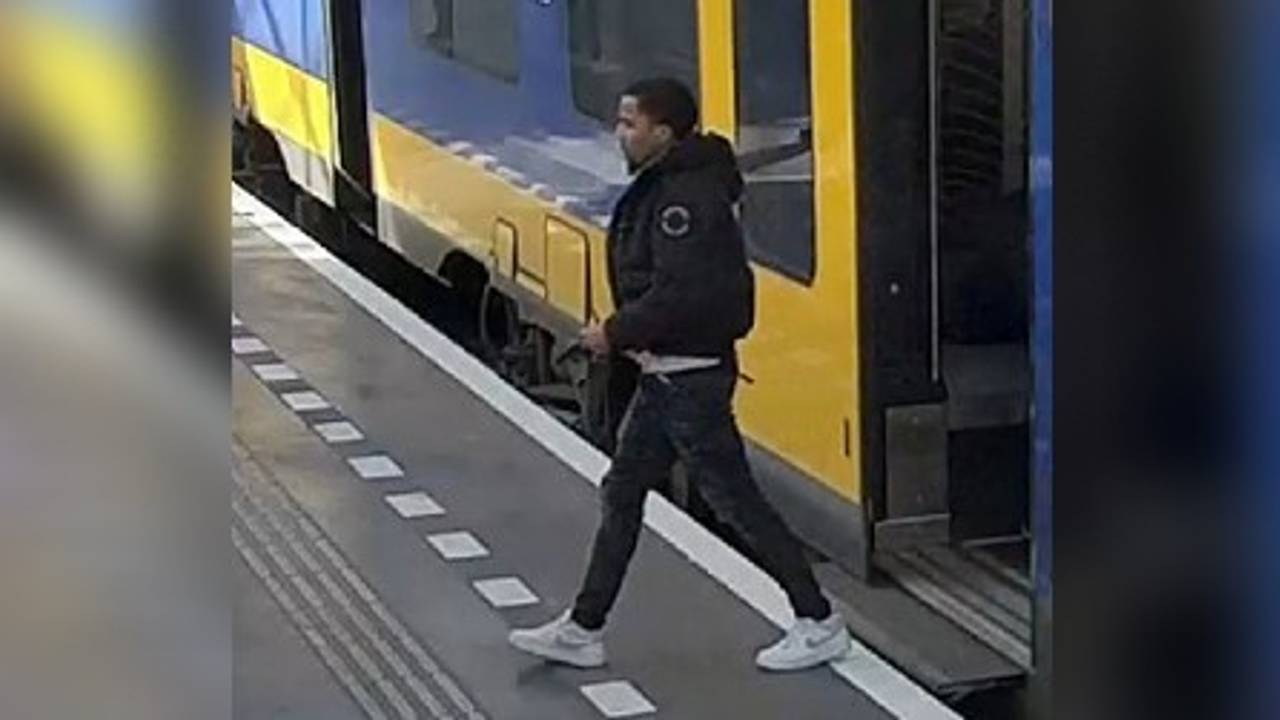 De man stapt de trein uit met een pistool in zijn hand (foto: politie).