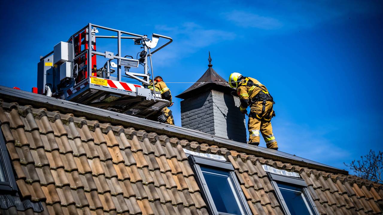 Met een hoogwerker kan de brandweer bij de schoorsteen komen (foto: Persbureau Heitink)
