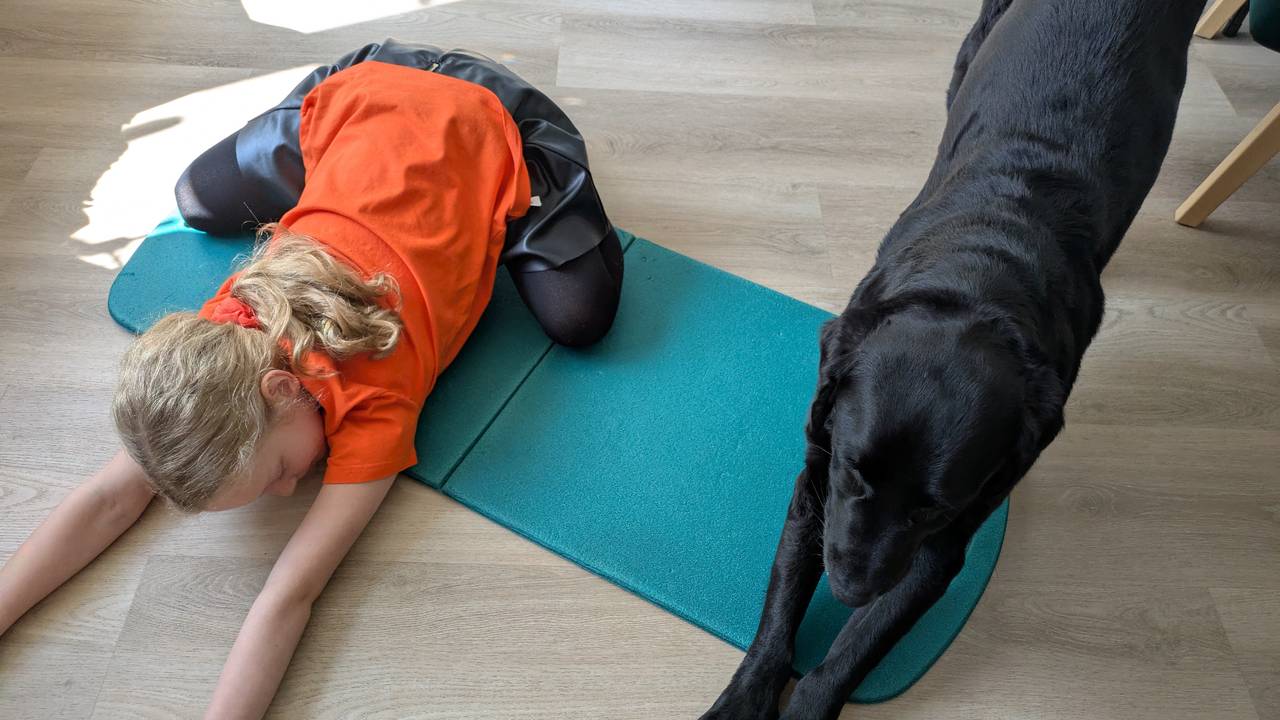 Hond en kind in yogapose om de dag soepel door te komen (foto: Monica).