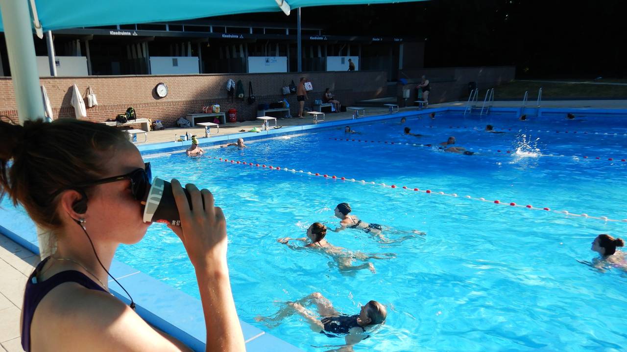 De badjuffrouw kijkt onder een parasol toe (foto: Paul Hermans).