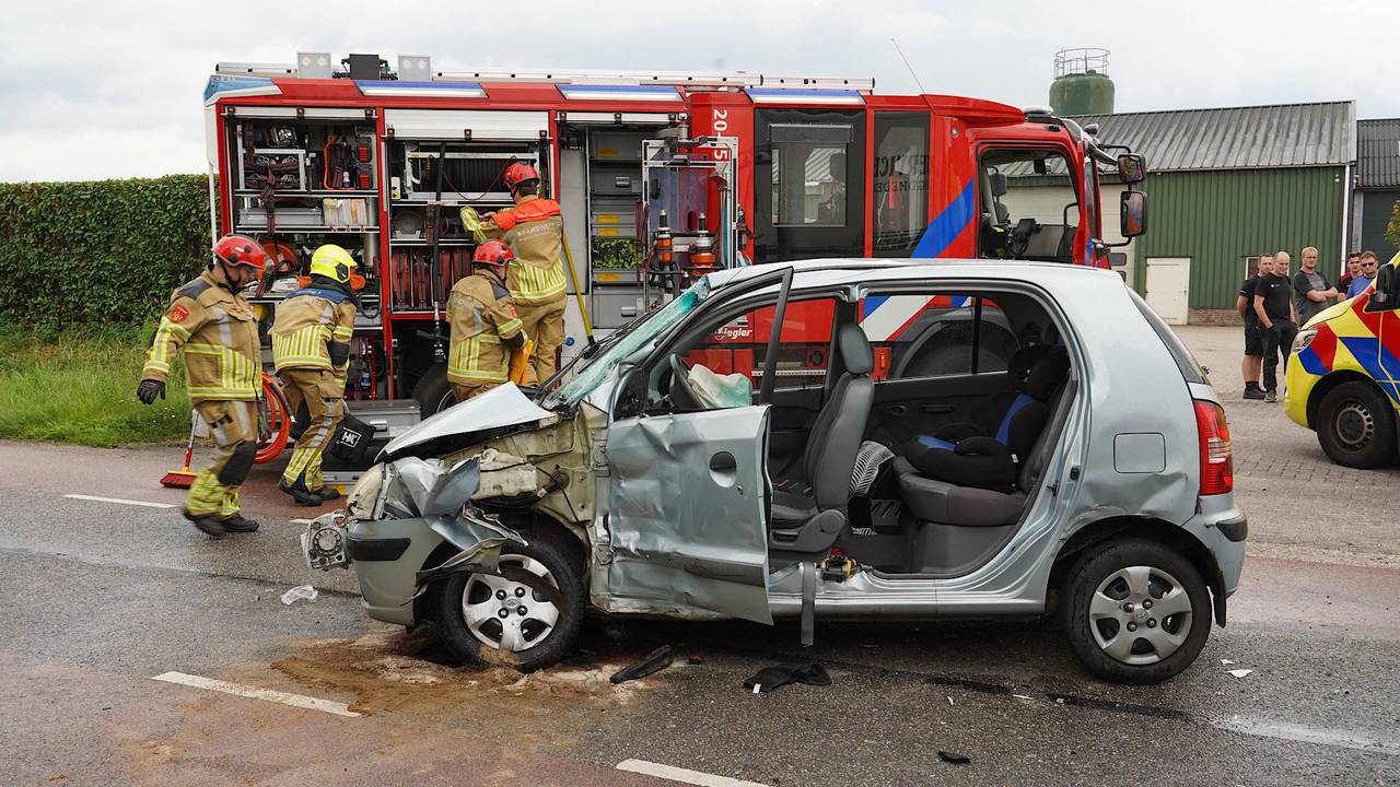 Vrouw bekneld in auto na botsing met vrachtwagen.