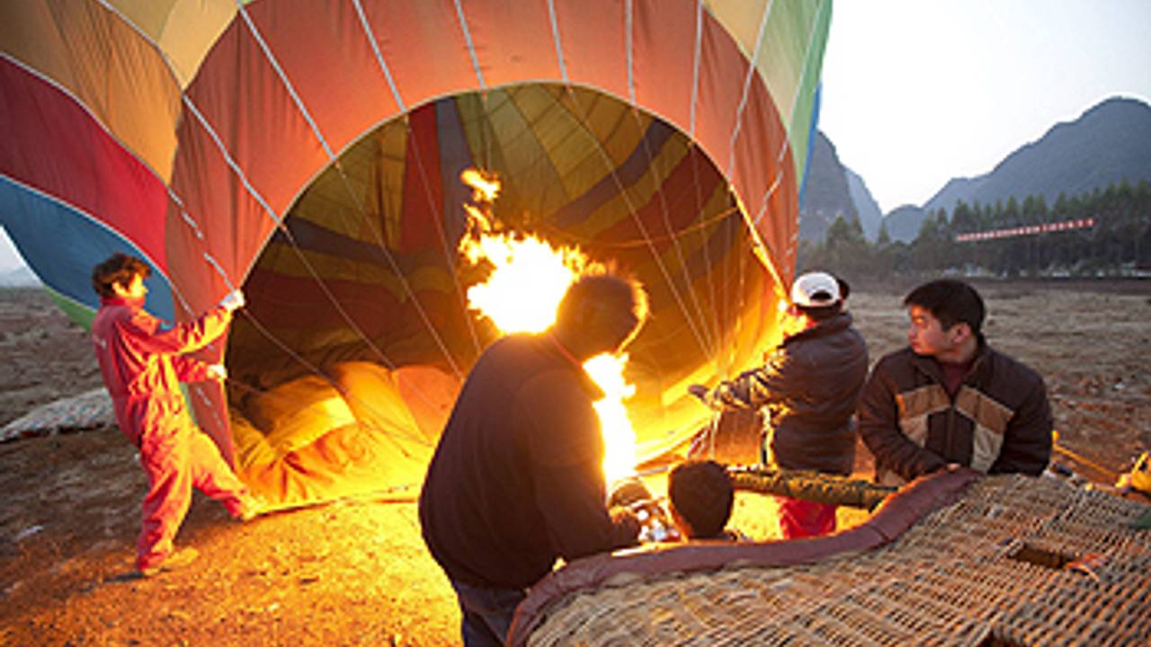 Chinese bestuurders bereiden een ballonvlucht voor bij de Zuid-Chinese stad Yangshuo. (Foto: ANP)