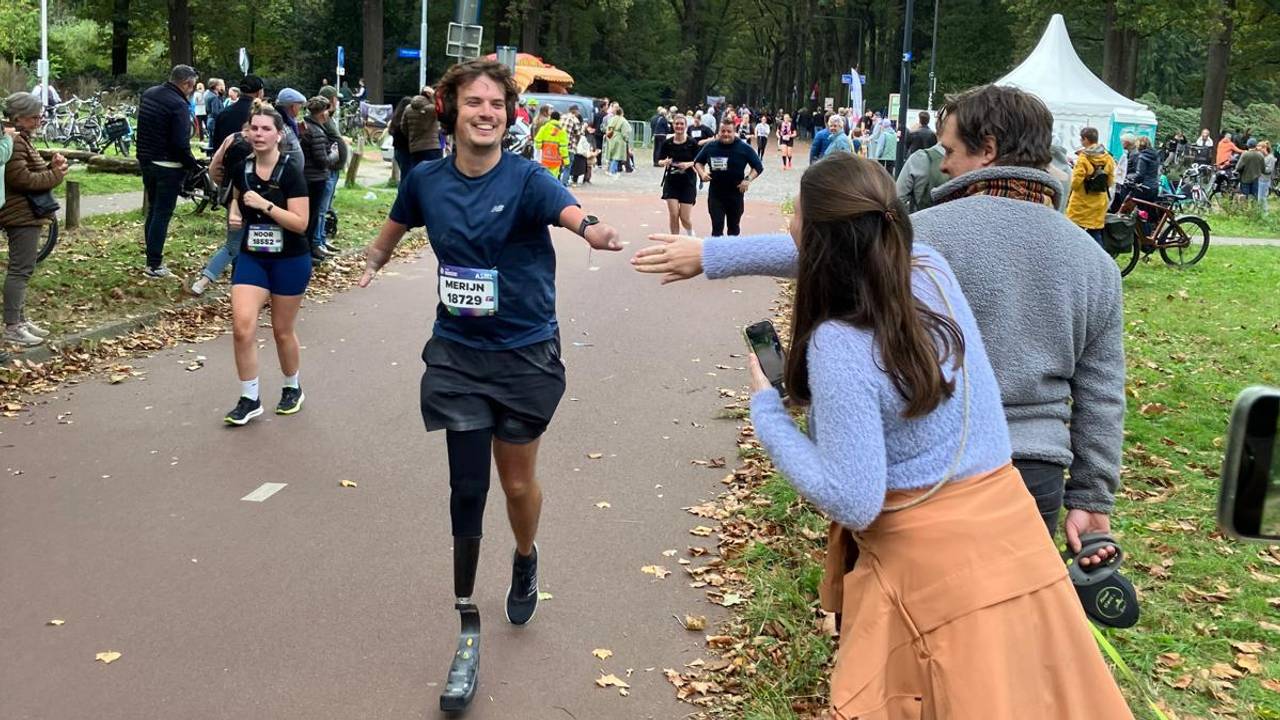 Merijn tijdens de halve marathon zondag, zijn vrouw Melissa en vriend Joep staan klaar voor de high-five (eigen foto).