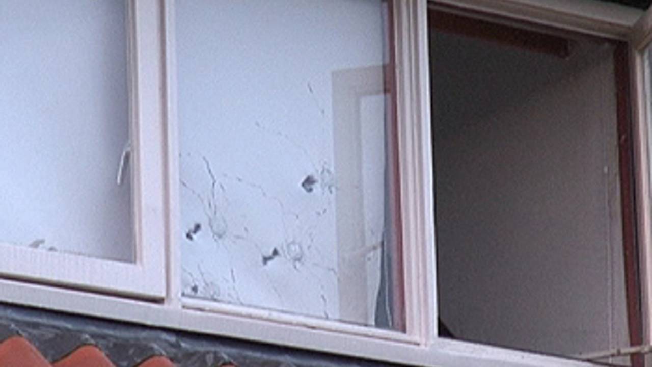 Kogelgaten in het slaapkamerraam van het hoekhuis