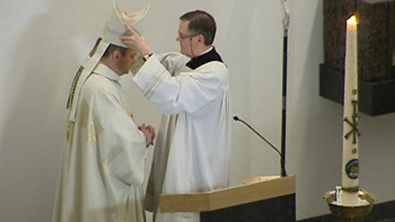 Bisschop Van den Hende (l.) krijgt de mijter opgezet.