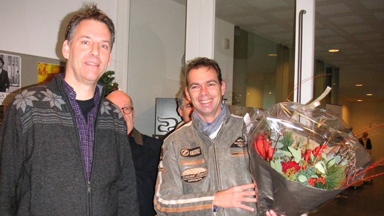 Directeur Jeroen van den Eijnde (links) overhandigt de bloemen.