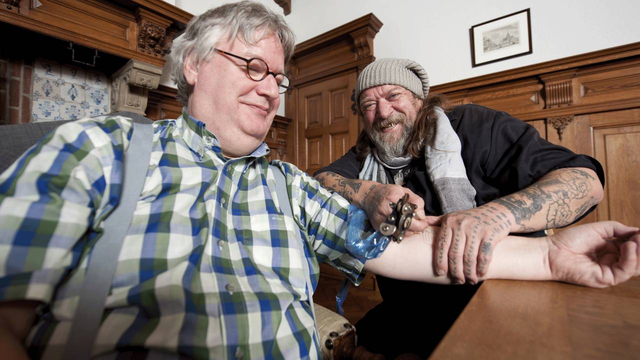 Henk Schiffmacher zet de tatoeage bij wethouder Ton Linssen