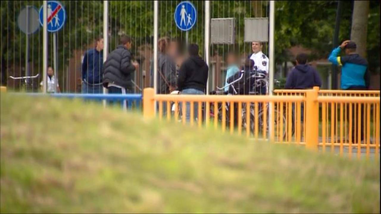 Politie praat met jongeren op het pleintje.
