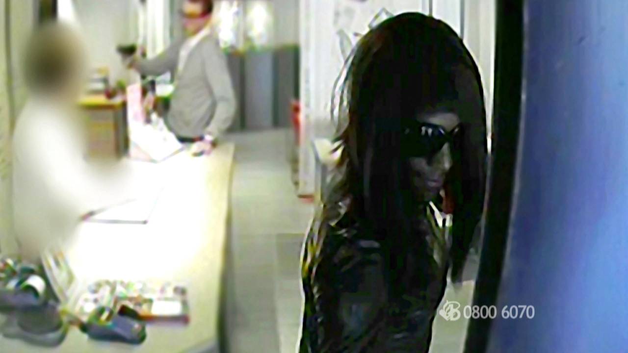 Blanke overvaller trekt pistool, overvaller in vrouwenkleren trekt deur dicht.