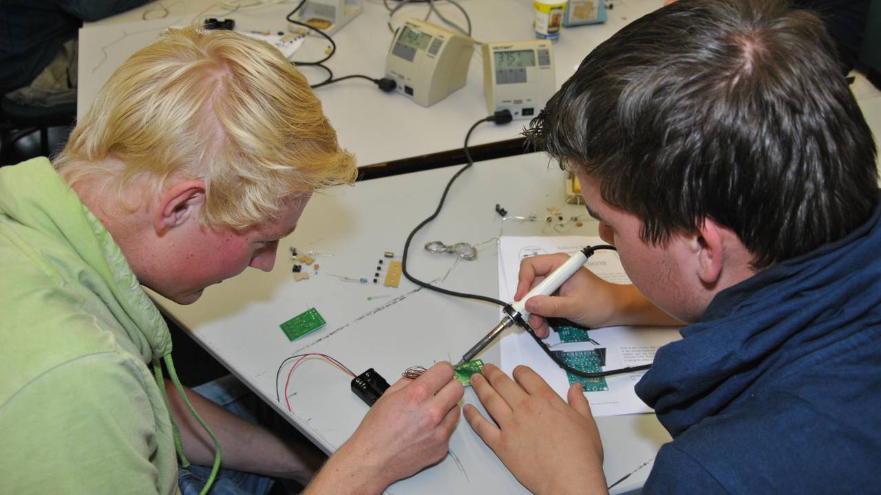 De studenten aan het werk met solderen