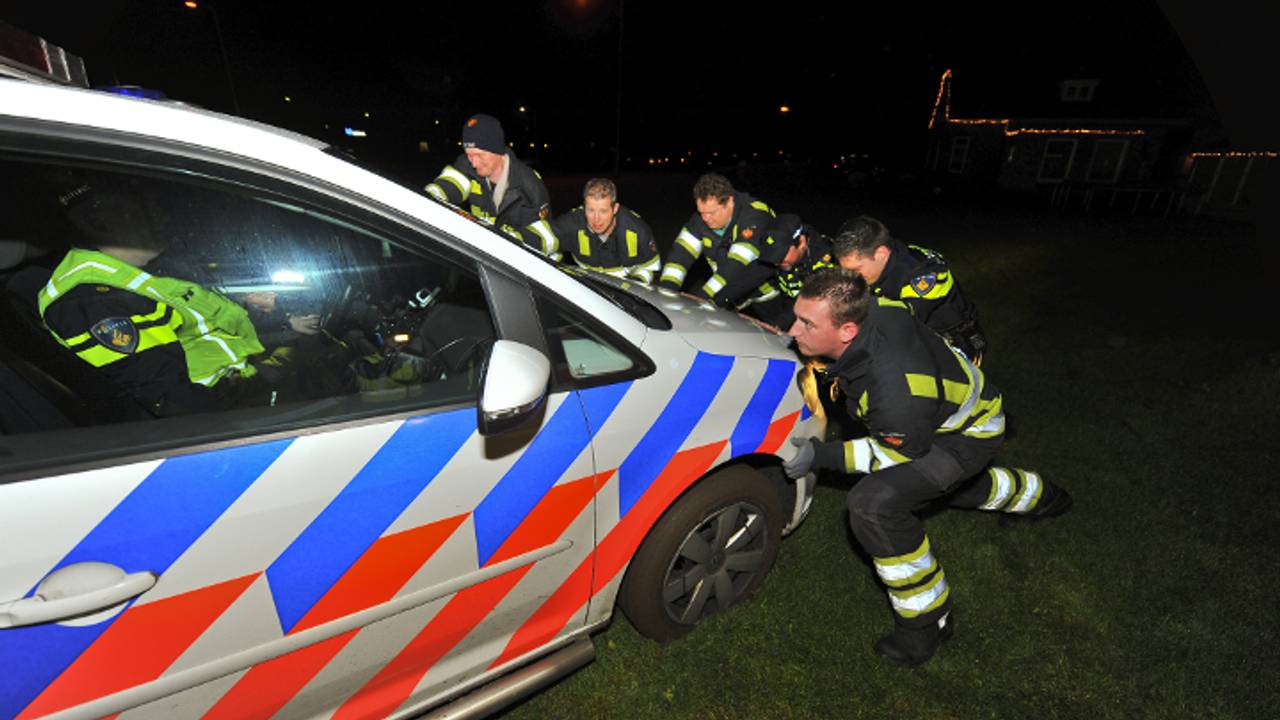 Politieauto uit de modder duwen (foto: Rico Vogels / SQ Vision)