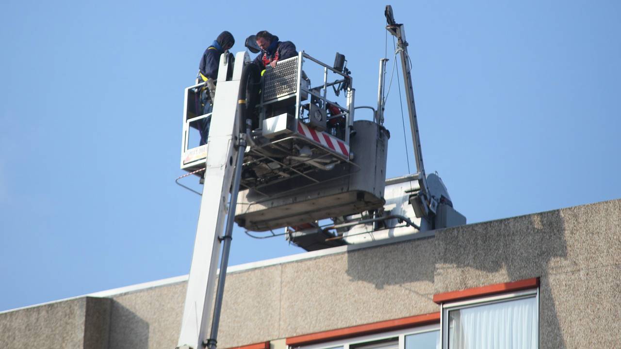 De brandweer haalt de reparateurs met een hoogwerker naar beneden. (Foto: Jeroen Stuve)
