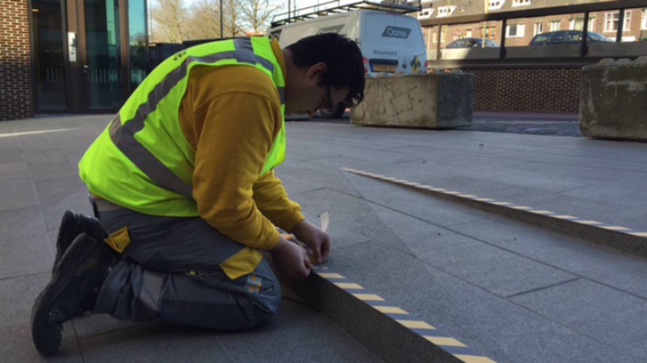 De trap in het station wordt voorzien van strips