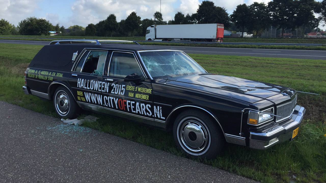 De vernielde lijkwagen.