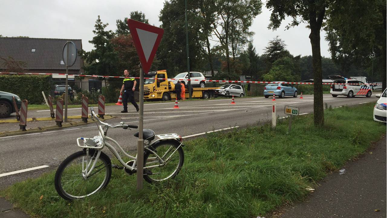 Kindje op de witte fiets raakte gewond, daarachter zie je de takelwagen twee auto''s weghalen. Foto:
