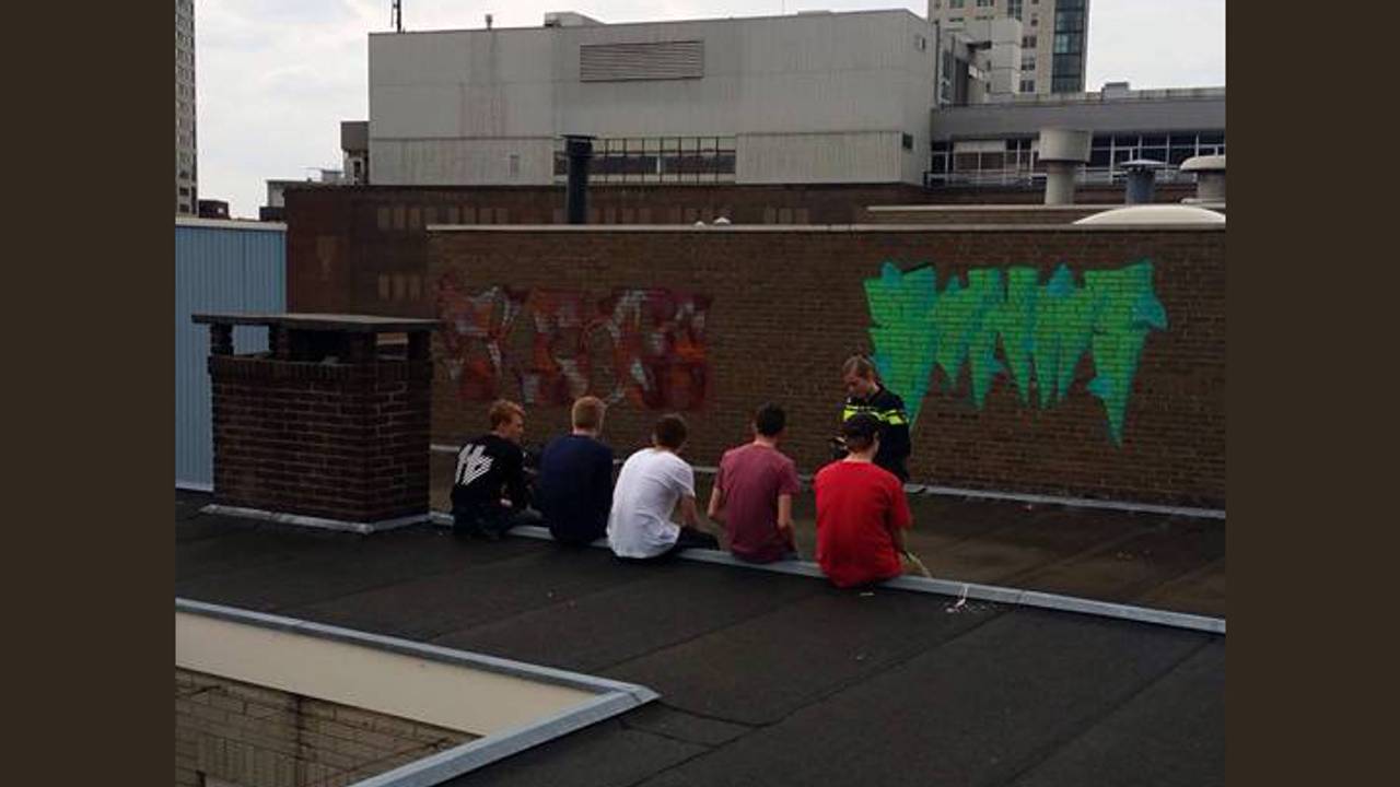 Het vijftal dat graffiti op de muur spoot. (Foto: politie Eindhoven/Facebook)