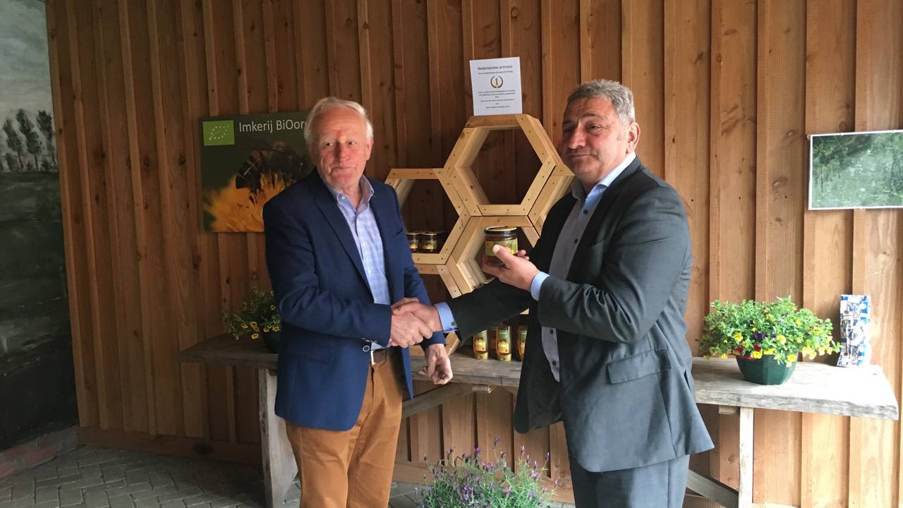 Toon van den Oord (links) en ZLTO-voorzitter Hans Huijbers proeven de biologische honing.