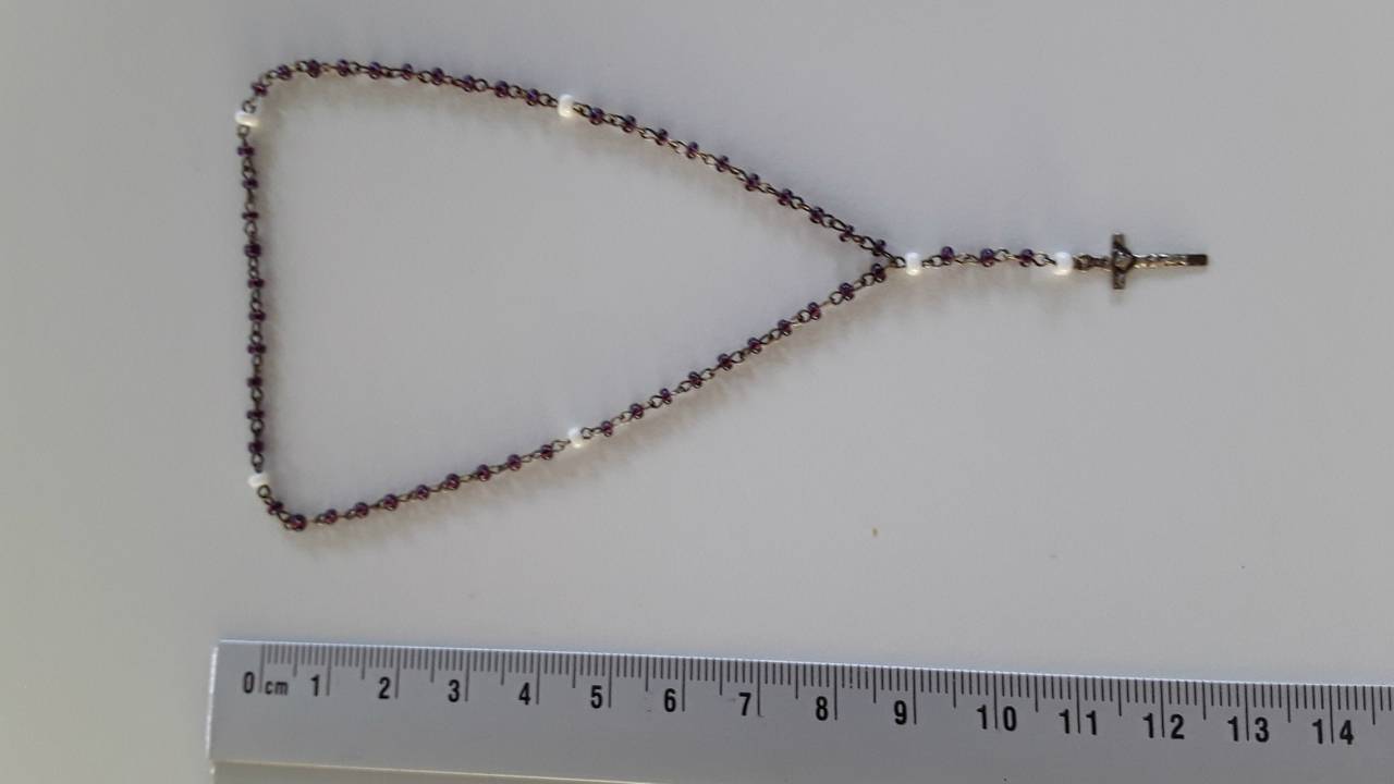 Wie is de standhoudster die deze rozenkrans te koop aanbood?