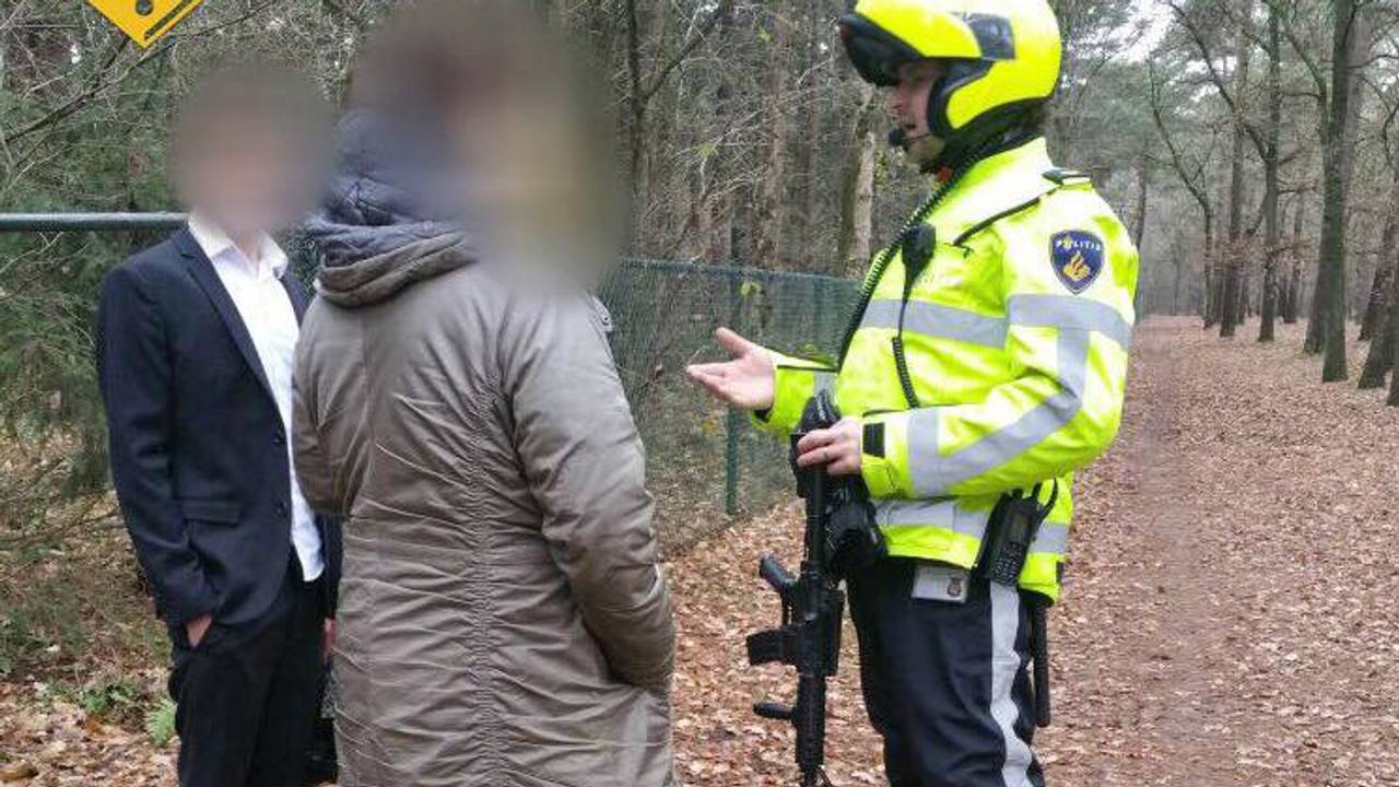 Jongen loopt met een automatisch geweer en een gasmasker over het spoor