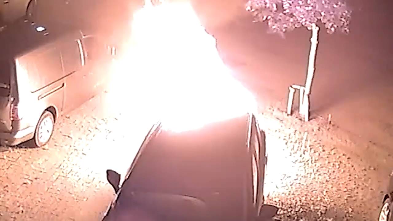 Vlammen slaan uit de auto van het gezin. Beeld: Jurgen Kamst