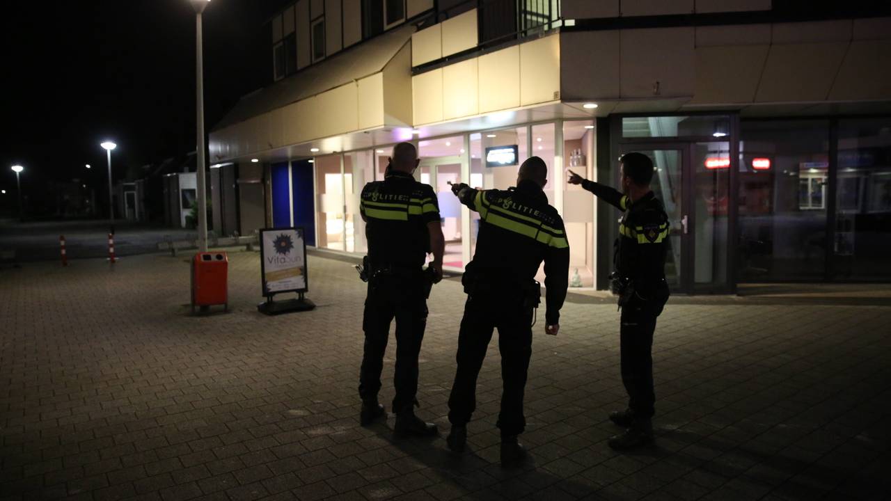 Agenten wijzen naar de straat waar de dader met het kapmes mogelijk naar toe is gerend. (Foto: Christian Traets)