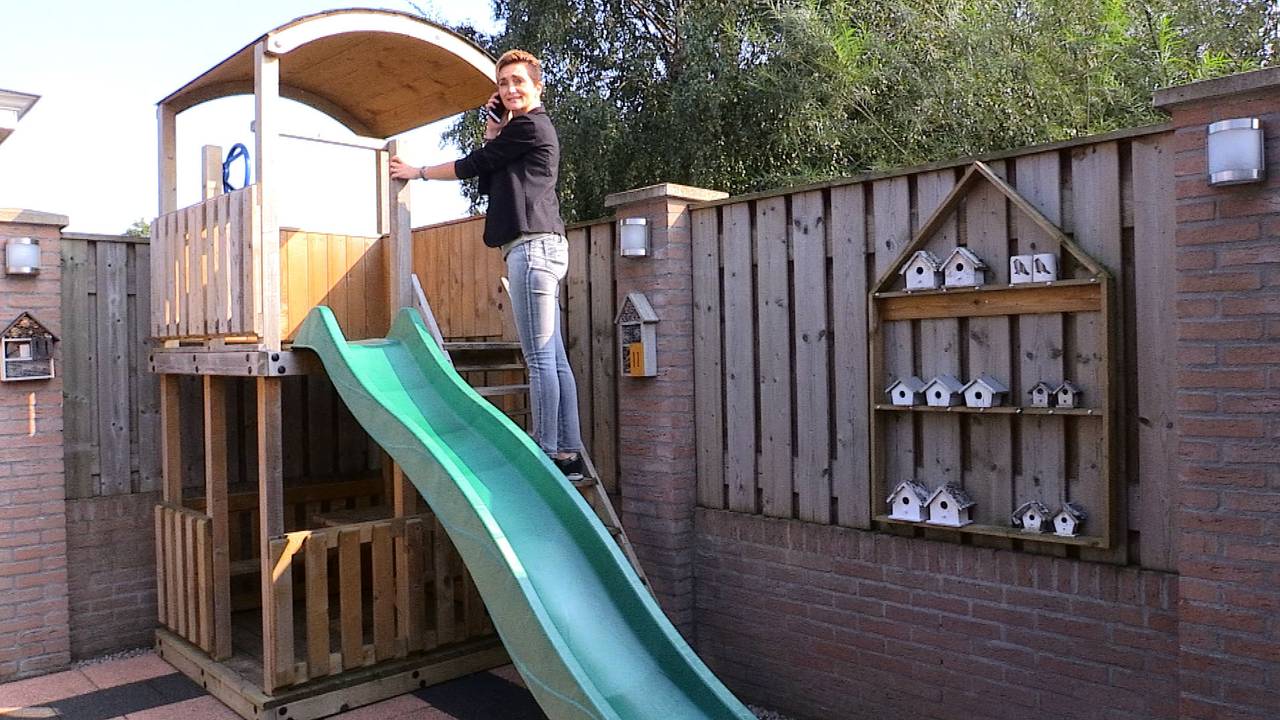 Heidi van Craaij doet voor hoe haar man het speelhuisje beklimt als hij moet bellen.