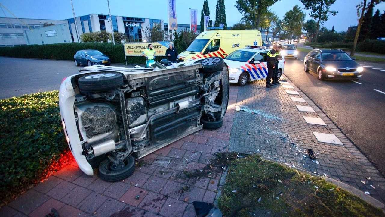 Een auto komt bij een botsing op z'n kant terecht. (Foto: Jeroen Stuve)