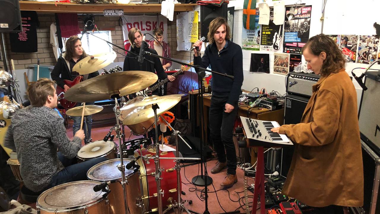 The Naked Sweat Drips repeteren in hun oefenruimte