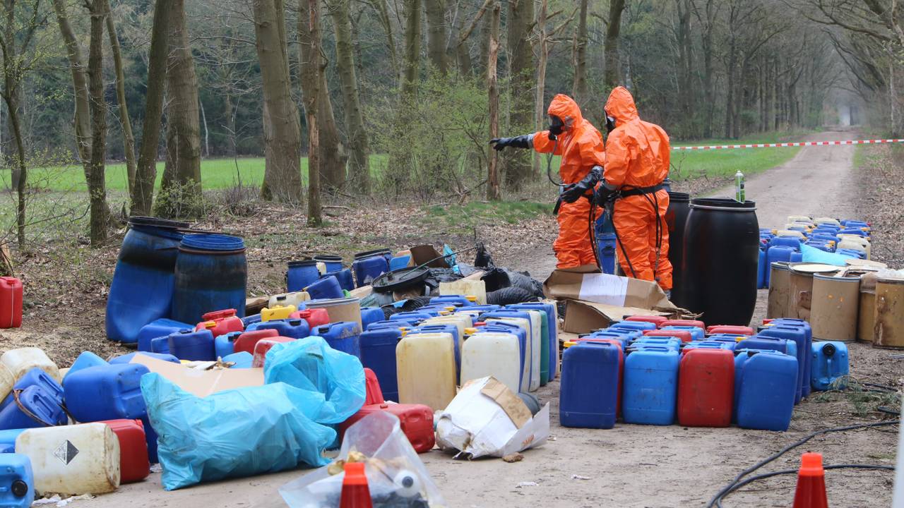 Oranje marsmannetjes nemen poolshoogte tussen de vaten met drugsafval (foto: Hans van Hamersveld).