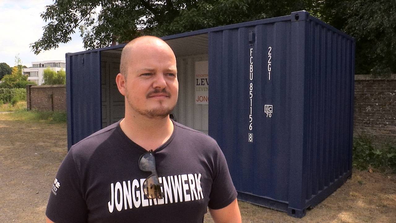 Initiatiefnemer Vic van Dijk naast de hangcontainer.