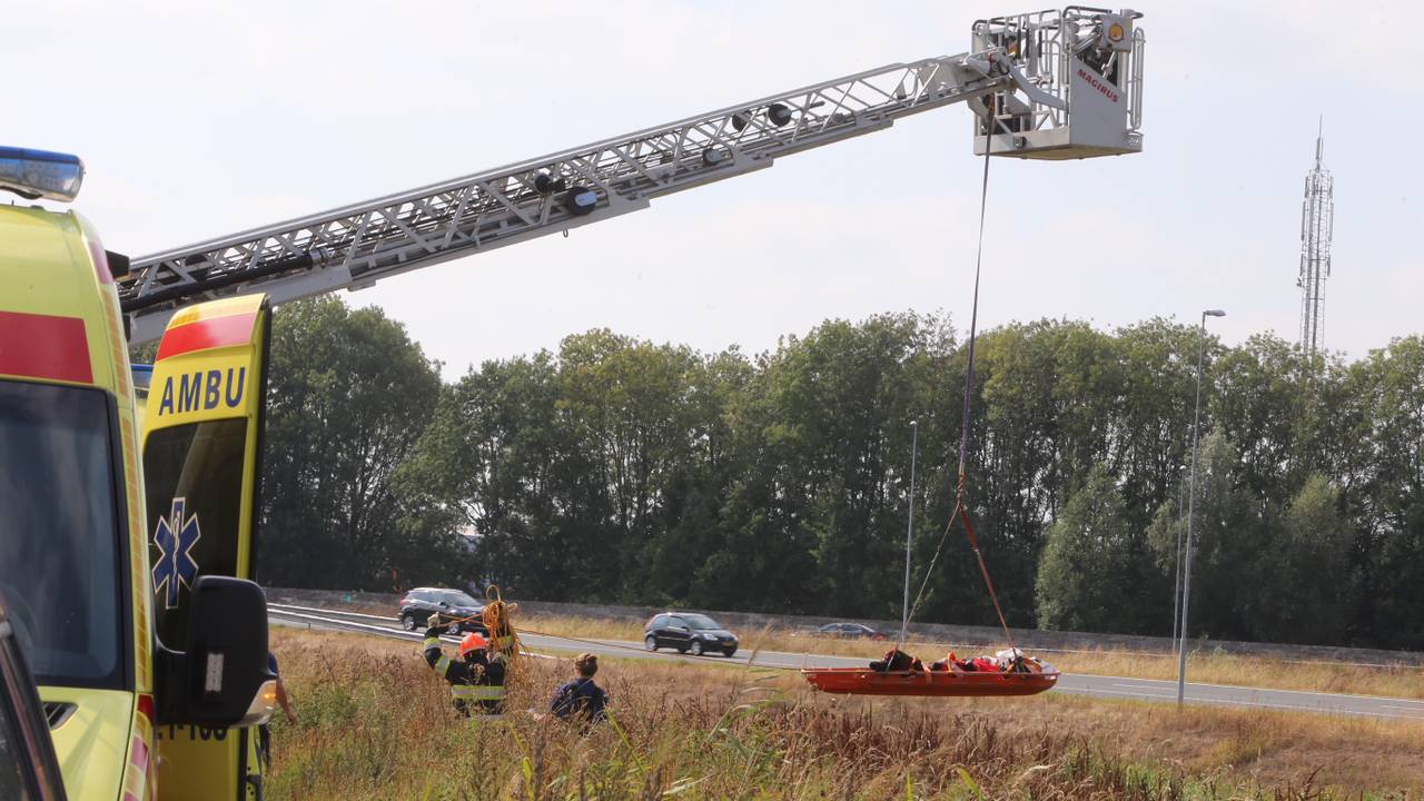 Eén van de inzittenden wordt met een ladderwagen uit de greppel gehaald (foto: Bart Meesters/Meesters Multi Media).