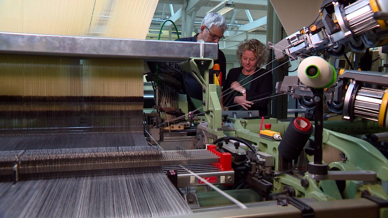 Babette en Michel bij een van de moderne weefmachines van het Textielmuseum.