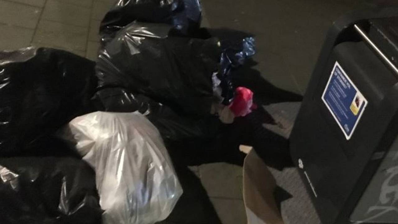 Volle afvalzakken naast een container. (Foto: Fleur Besters)