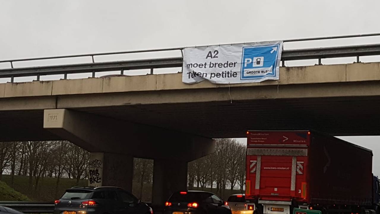 Er hangt een spandoeken over de A2 om aandacht te vragen voor het fileleed. FOTO: Merel de Leuw