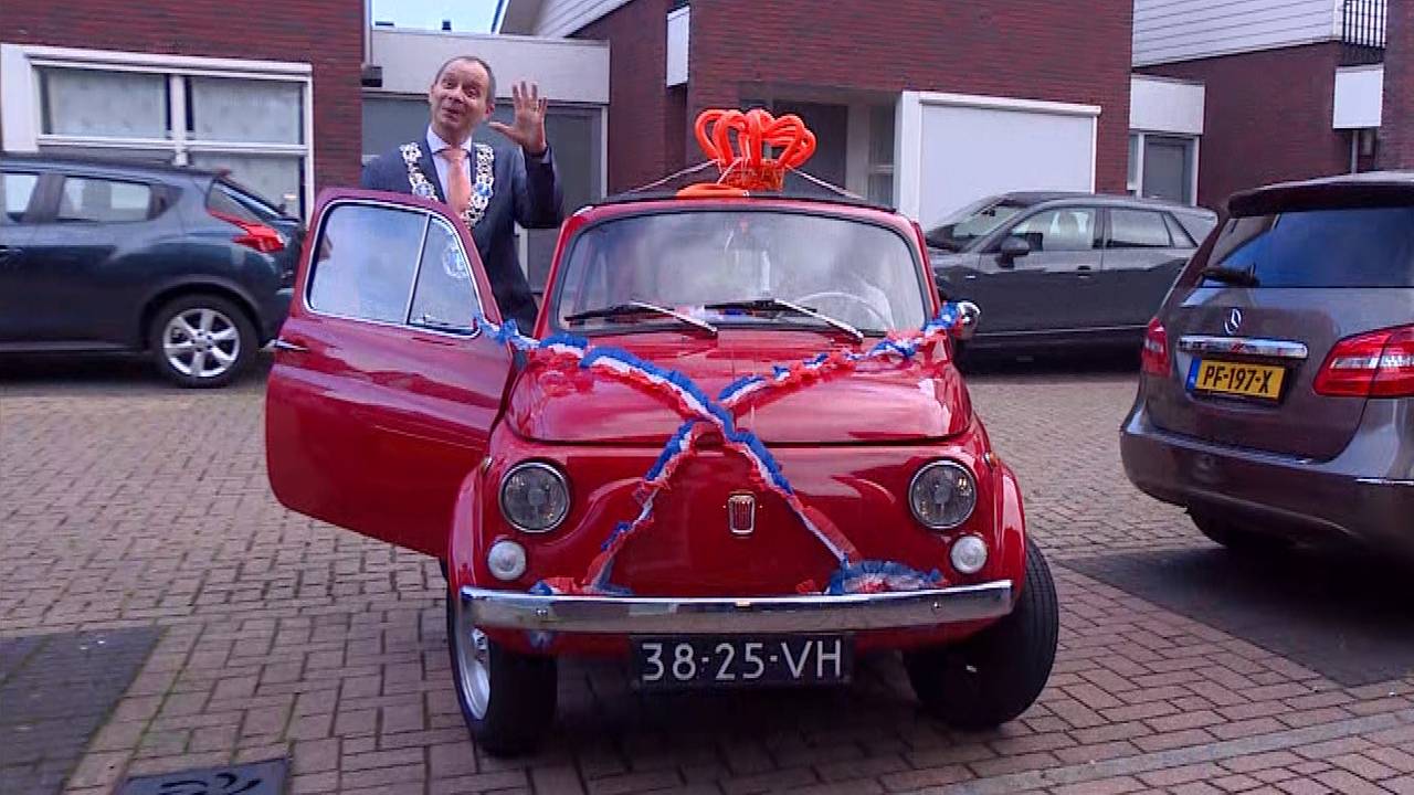 Burgemeester Anton Ederveen gaat in een Fiat 500 bij de gelukkigen langs.