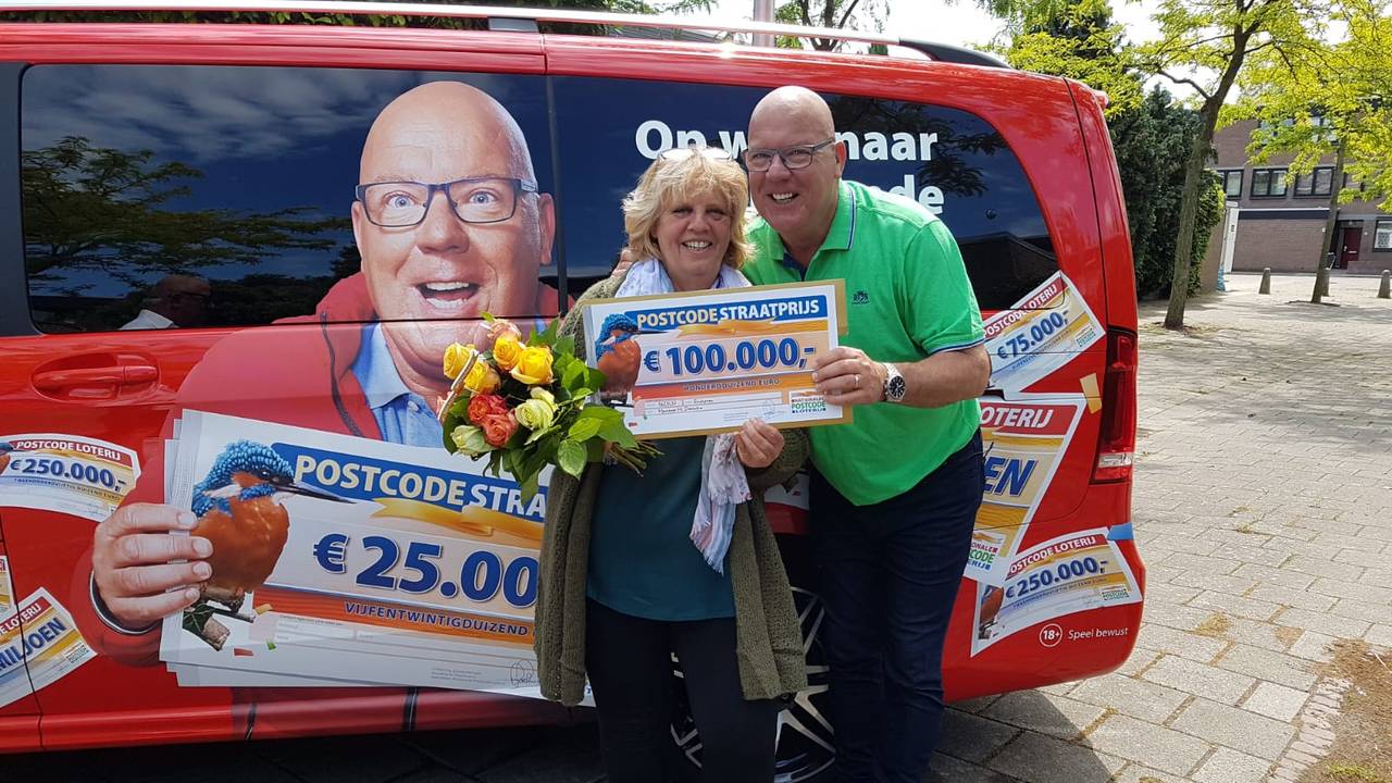 Marianne neemt de cheque van 100.000 euro in ontvangst.
