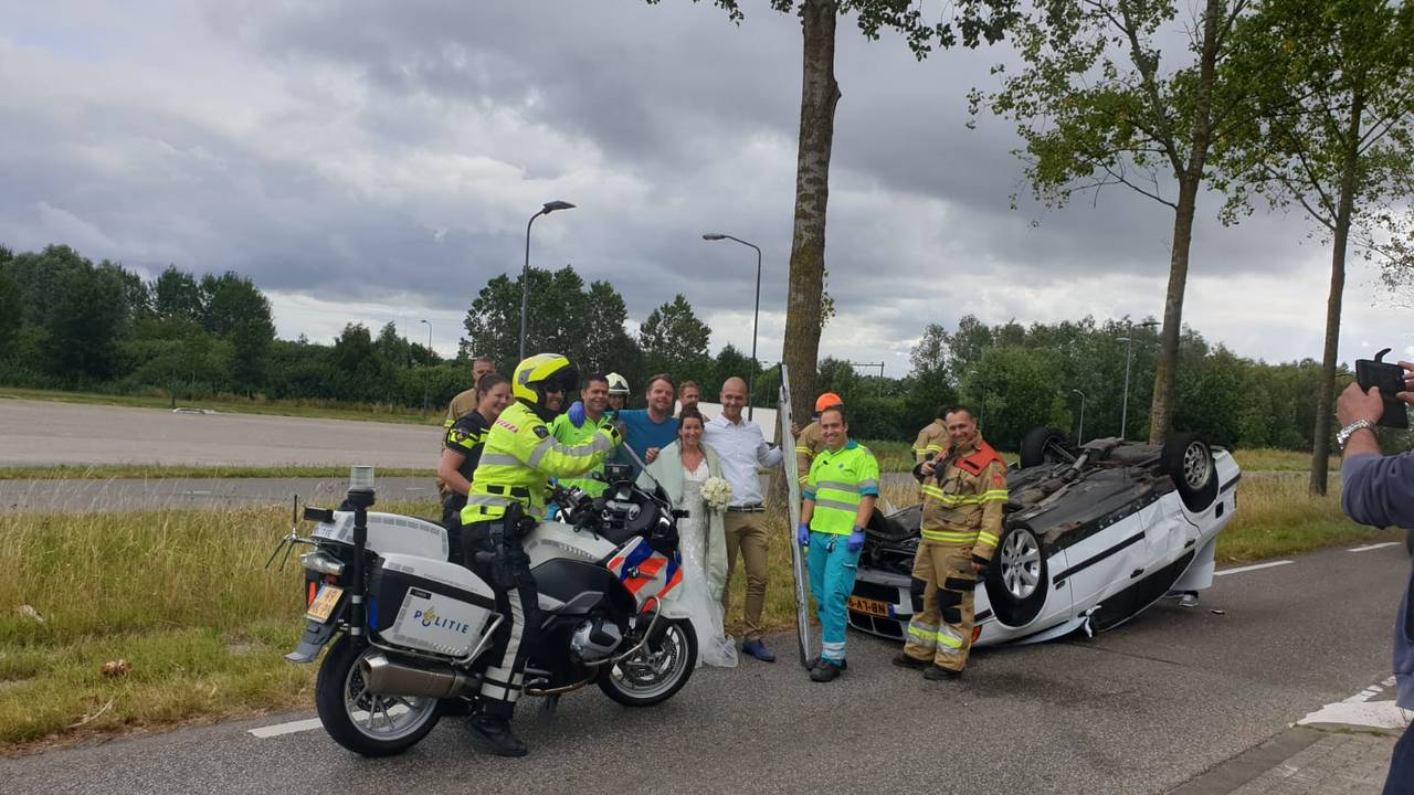 Het bruidspaar na het ongeluk met alle hulpverleners (Foto: Ruud van Rosmalen).