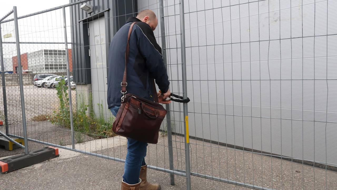 Een ambtenaar van de gemeente verwijdert het slot van het recyclingsbedrijf (foto: Perry Roovers SQ Vision Mediaprodukties).