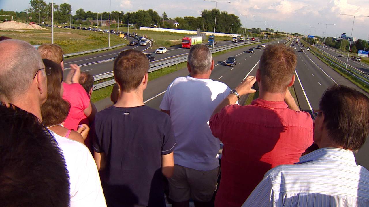 Duizenden mensen zien de rouwstoet voorbijkomen.