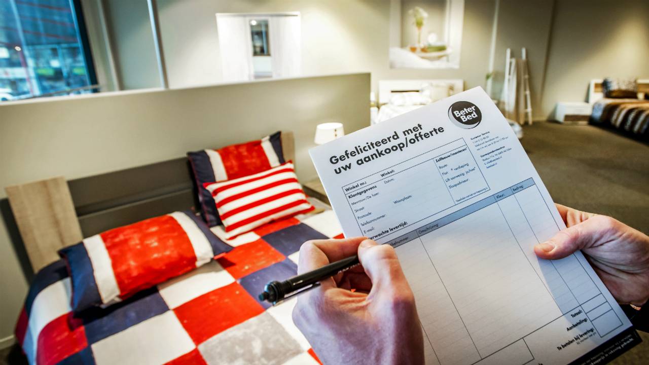 Een verkoper houdt een offerte vast voor een aankoop bij beddenwinkel Beter Bed. (Foto: ANP)