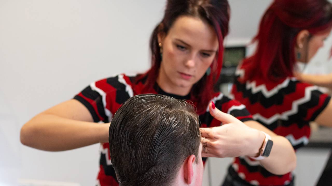 Sylvia Wenselaars knipt een klant.