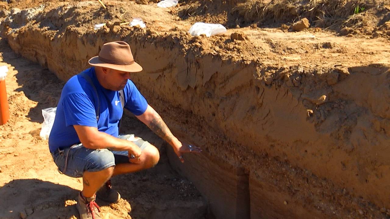 Archeoloog Nico van der Feest laat stukjes van de weg zien.