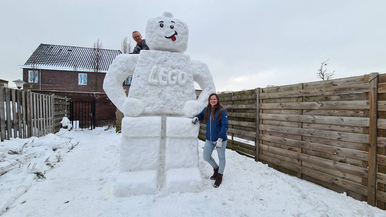 Kylian en Debby Schiks bij hun ruim drie meter hoge sneeuwpop (foto: Noël van Hooft).