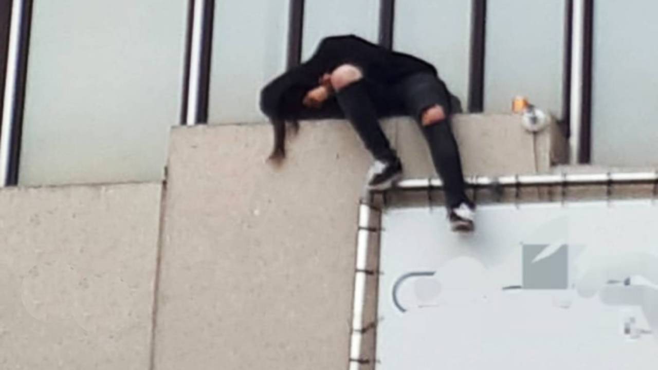 De slaper op de balustrade van het gebouw in Best (foto: Instagram politie Best-Oirschot).