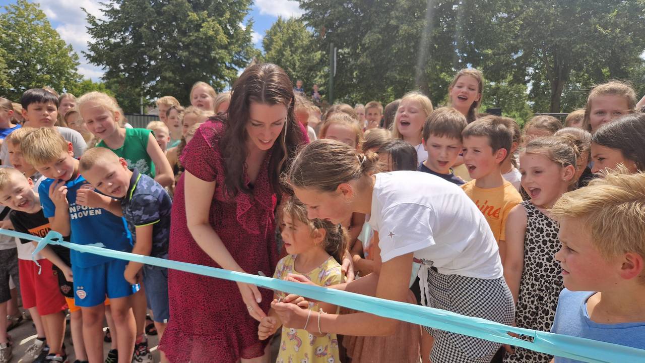 De jongste en oudste leerling van de school knippen het lintje door bij de opening van de tijdelijke locatie