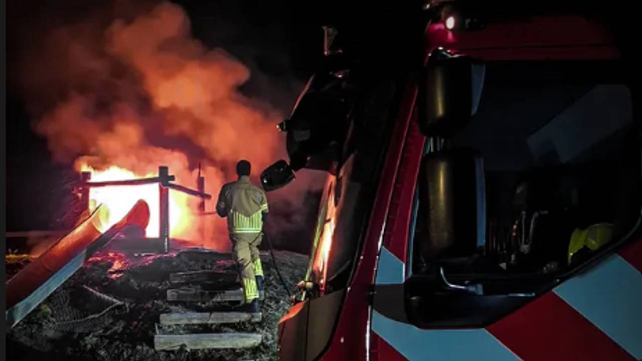 De vlammen slaan uit de bovenkant van de glijbaan (foto: politie Markdal).
