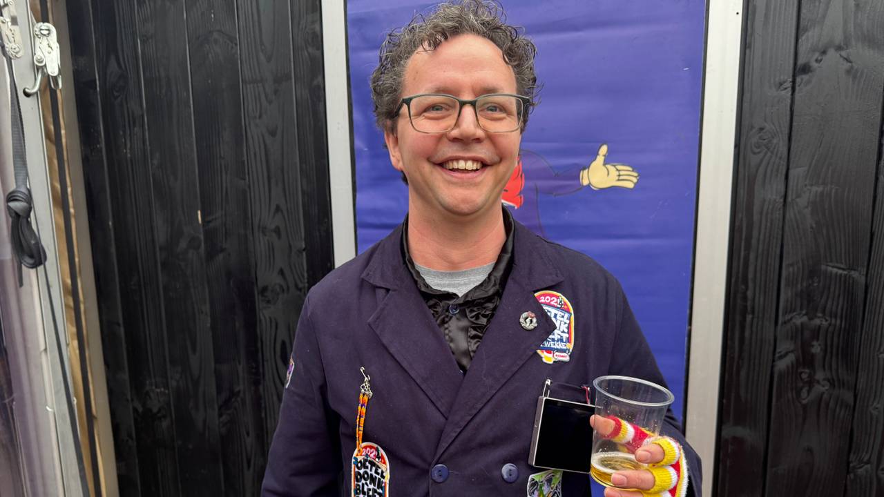 Achter het bierglas van Paul Groenendaal hangt het digitale embleem dat vooral in het donker goed zichtbaar is (foto: Thijs den Ouden).