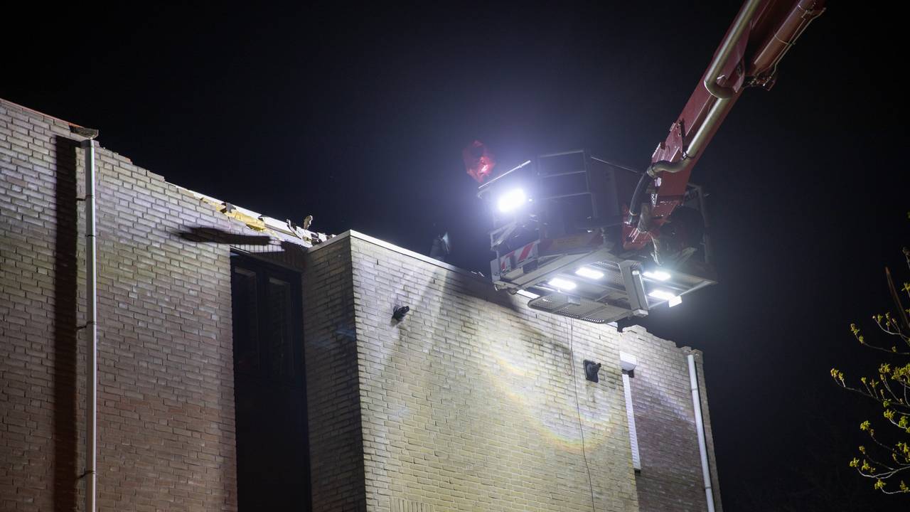 De brandweer heeft via een hoogwerker de loszittende delen van de daken van de huizen in Roosendaal verwijderd (foto: Christian Traets/Persbureau Heitink).